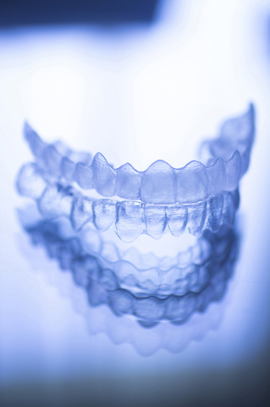 a clear plastic teeth on a blue surface